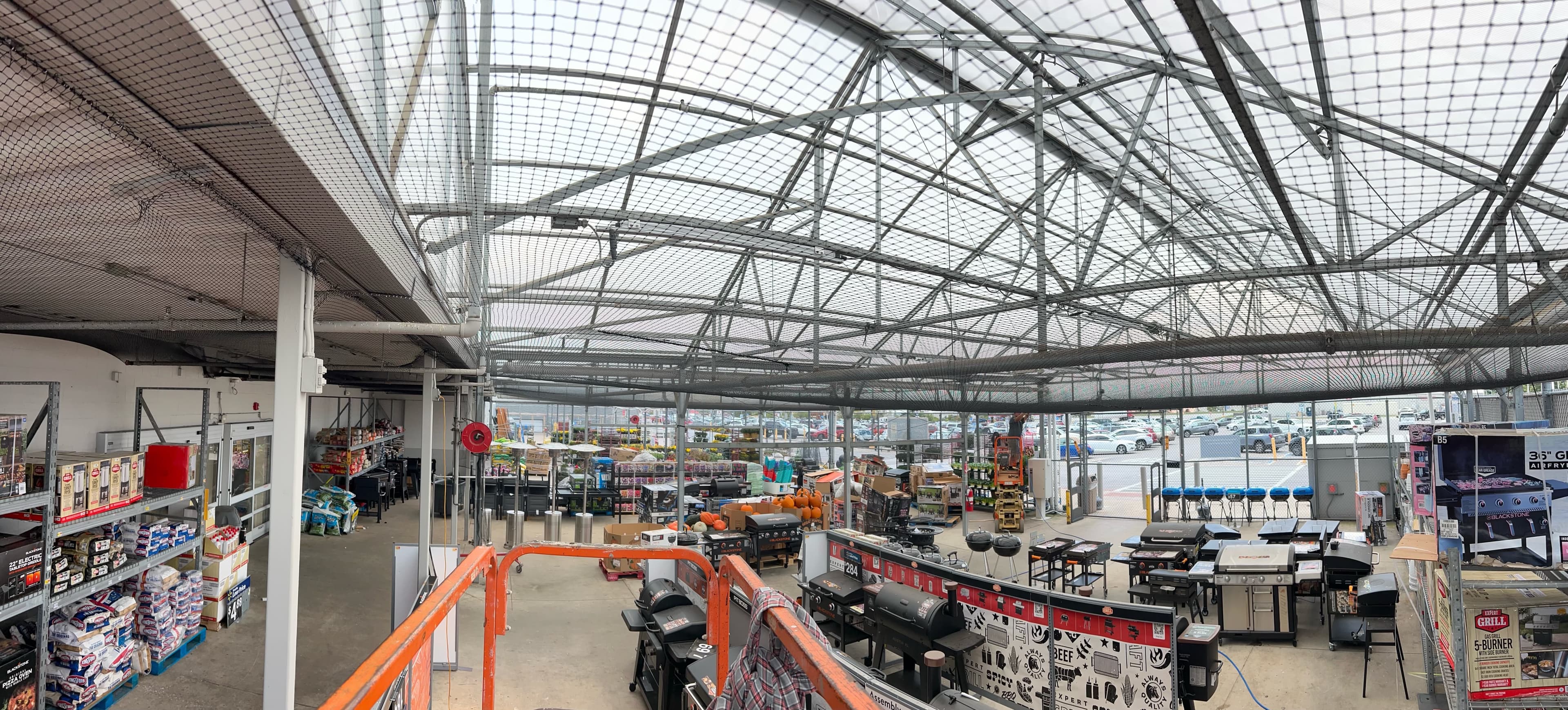 Large commercial retail space with bird netting overhead