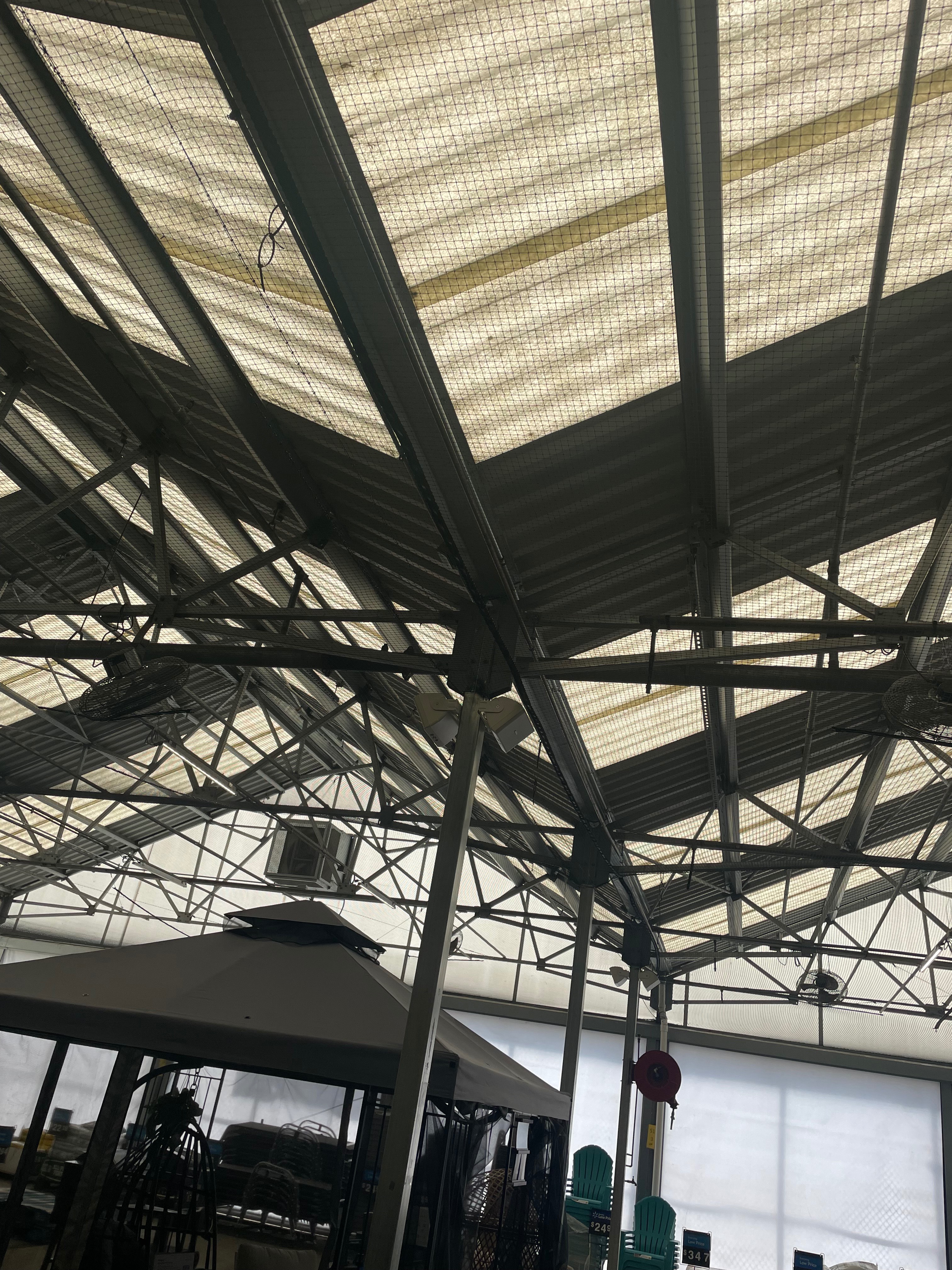 Bird netting installation on industrial greenhouse structure